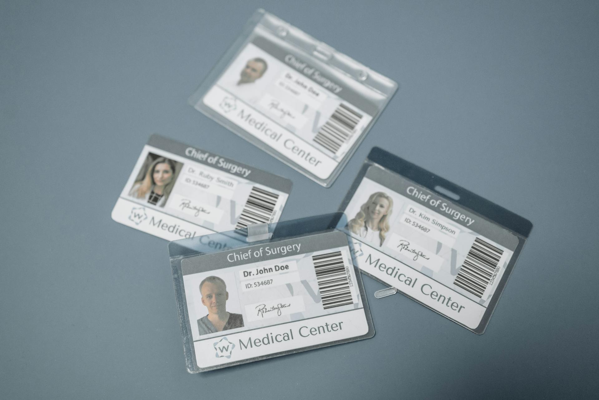Medical staff ID badges labeled “Chief of Surgery” from a medical center, arranged on a gray surface.